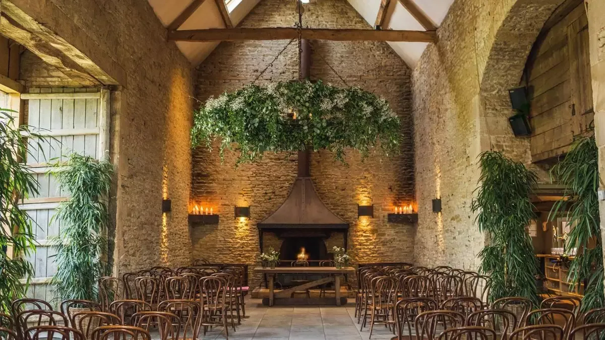 The ceremony barn: Cotswold stone, open beams and a stone fireplace